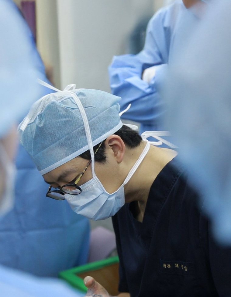 수술실에서 수술 중인 최문섭 원장(수술모·마스크·남색 수술복)